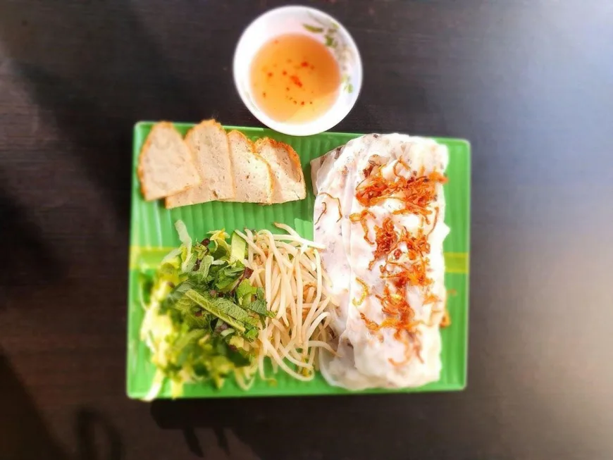Steamed rice rolls banh cuon served with fresh herbs and dipping sauce in Hanoi