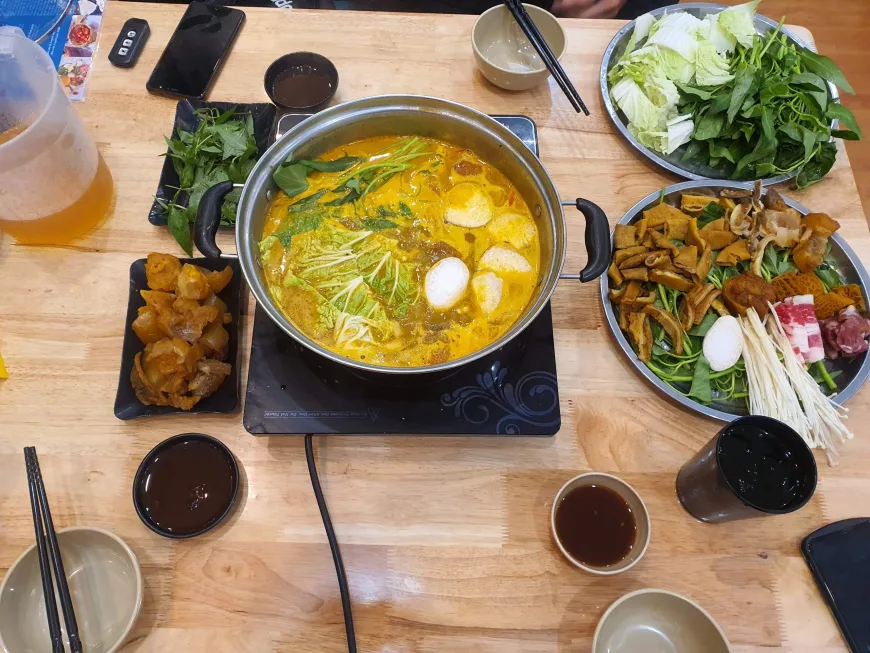 Vietnamese hot pot lau bubbling with fresh vegetables and meat in Hanoi