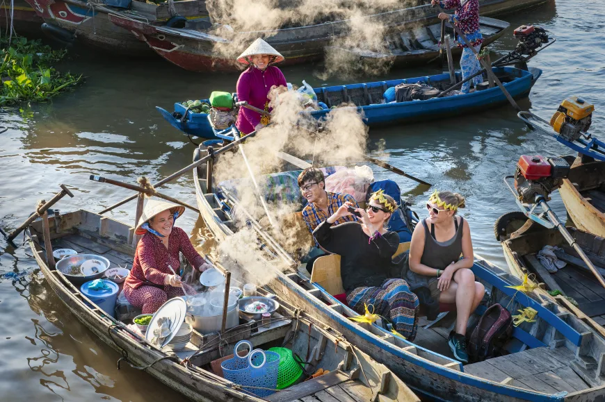 Market on the river with boats trading at dawn